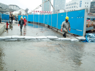 隧道施工的工人们在路面上构筑"挡水墙".范云 彭翔 摄影报道